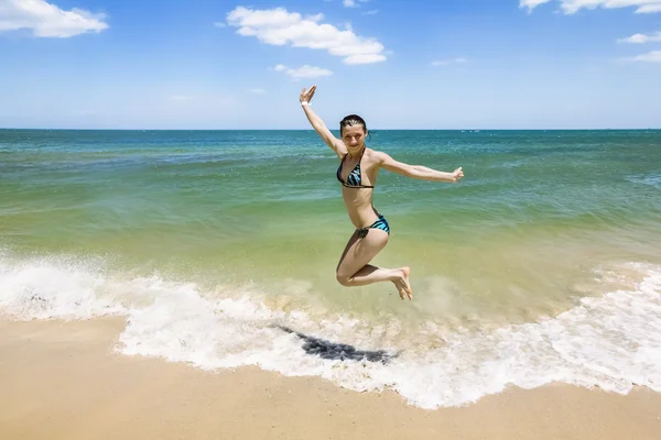 Girl jumping and splashing in the waves of the sea — Stock Photo, Image