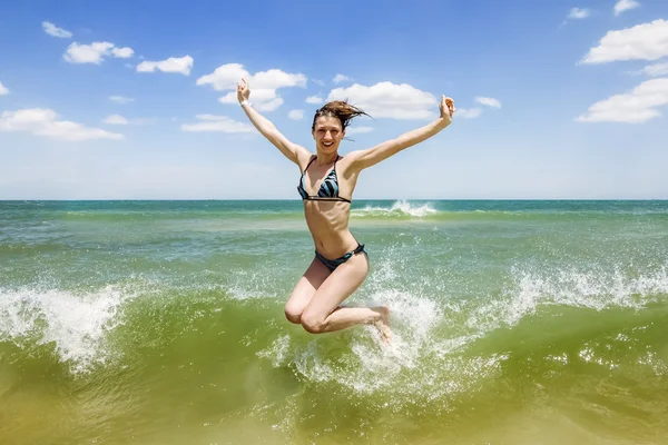 Girl jumping and splashing in the waves of the sea — Stock Photo, Image