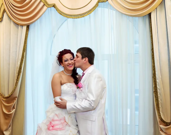 Novia de beso de novio en el fondo de la ventana — Foto de Stock