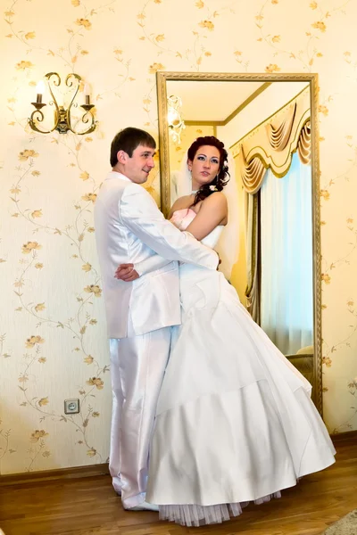 Brudgummen allomfattande bruden nära spegeln — Stockfoto