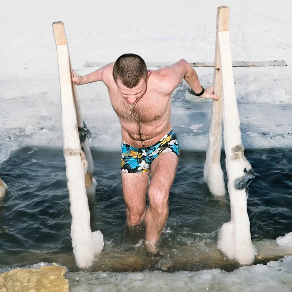 L'uomo esce dal ghiaccio sul lago in inverno — Foto Stock