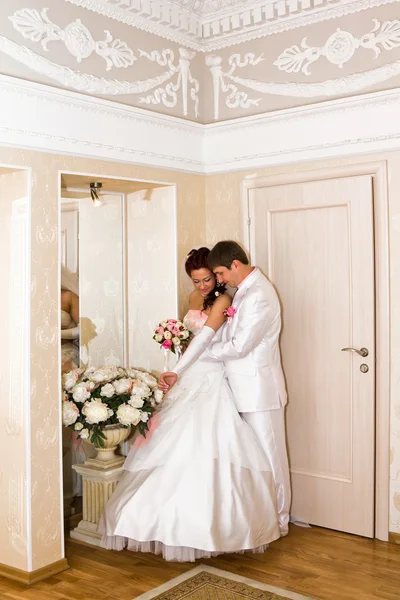 El novio abrazando novia cerca del espejo — Foto de Stock