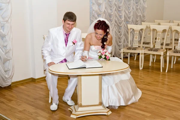 Bride and groom signs the book — Stock Photo, Image