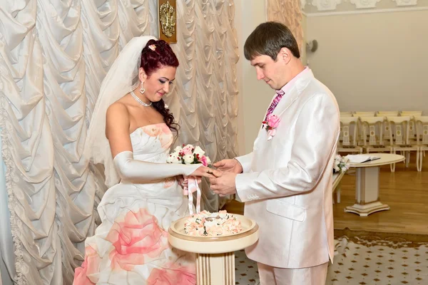 Nevěsta a ženich nosí navzájem kroužky — Stock fotografie