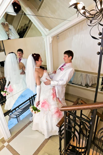 El novio abrazando novia cerca del espejo — Foto de Stock