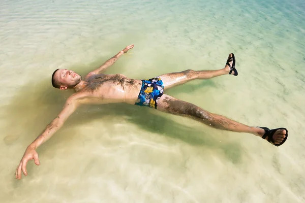 Bir adamın elini dead sea Israel yapılan su dayanmaktadır — Stok fotoğraf