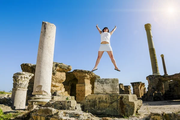 Meisje in sprong te midden van de ruïnes van Carthago in Tunesië — Stockfoto