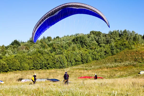 Parapentes se preparan para volar contra el telón de fondo del hermoso paisaje — Foto de Stock