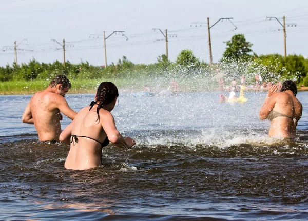 Jovens pular e espirrar ao redor no lago — Fotografia de Stock