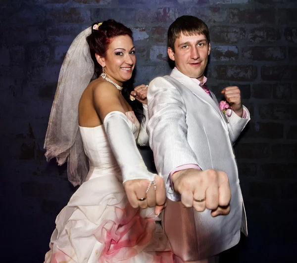 Novia y novio posando para la cámara en un estante con anillos en las manos — Foto de Stock