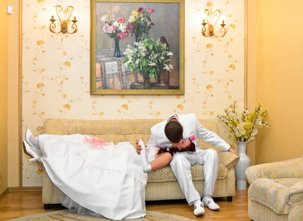 Жених целует невесту лежа на коленях — стоковое фото