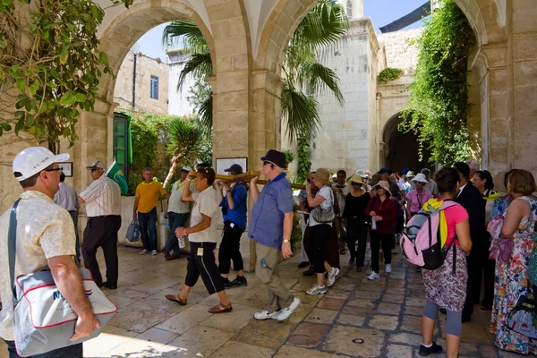 Pilgrims could pray with the cross go on Way of the Cross on Via Dolorosa. Jerusalem — Stock Photo, Image