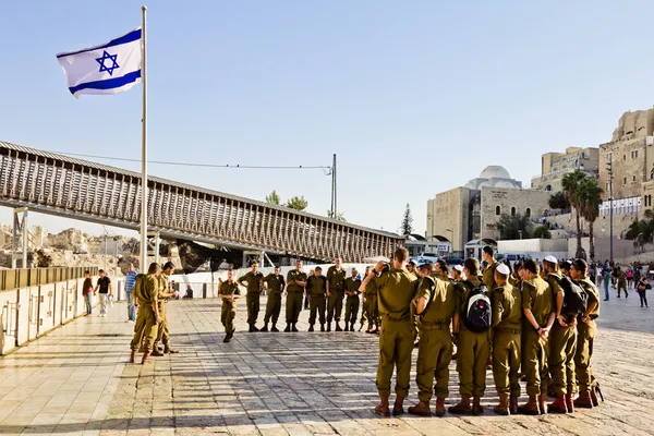 En trupp av israeliska soldater på torget nära den västra väggen under nationella flagga (jerusalem) — Stockfoto