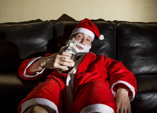 Babbo Natale ubriaco posa con una bottiglia di whisky — Foto Stock