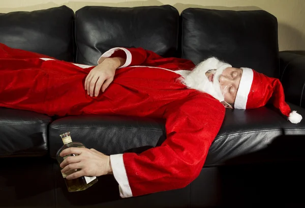 Babbo Natale ubriaco posa con una bottiglia di whisky — Foto Stock