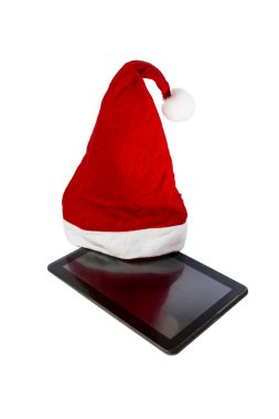 beyaz zemin üzerinde bir tablet PC'de Noel Baba şapkası olduğunu