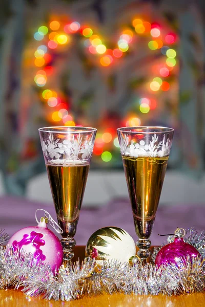 Goblets with sparkling wine and festive toys amid colorful heart — Stock Photo, Image
