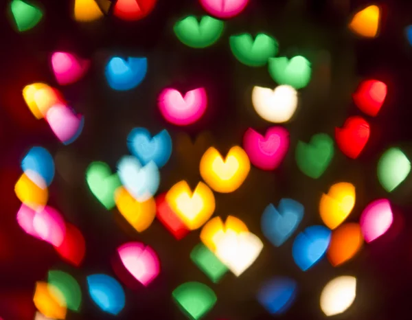 Round multicolor heart-shaped bokeh on a black background Royalty Free Stock Photos