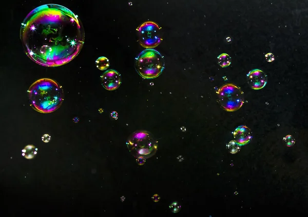 Burbujas multicolores sobre un fondo oscuro — Foto de Stock