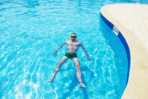 Man swims in the pool on a bright sunny day — Stock Photo, Image