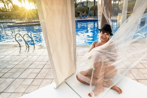 Girl sitting on a Beach Lounge Chair at the pool — Stock Photo, Image