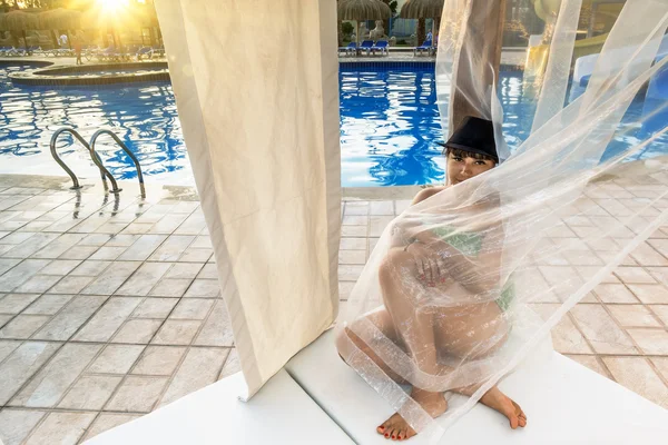 Ragazza seduta su una sdraio in piscina — Foto Stock
