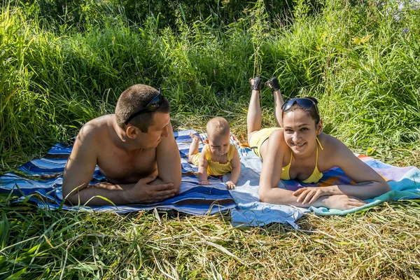 Mladá rodina matka otec a dítě venku na letním dni jsou tan — Stock fotografie