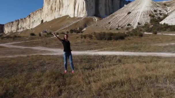 Een meisje poseert tegen de achtergrond van de White Rock Ak Kaya op de Krim. — Stockvideo