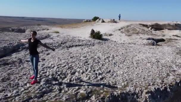 Menina posa de pé na borda no topo da rocha branca Ak Kaya na Crimeia. — Vídeo de Stock