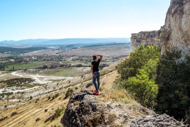 Beyaz Kaya Ak Kayası. Suç 10 Eylül 2021. Kırım üzerindeki Beyaz Kaya Ak Kaya 'nın tepesinde duran kız poz veriyor..