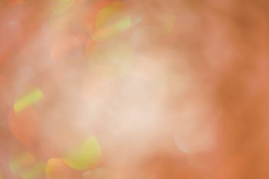 Soyut bokeh ışık arkaplanı. Açık kahverengi turuncu ve yeşil parıltılı defocus..