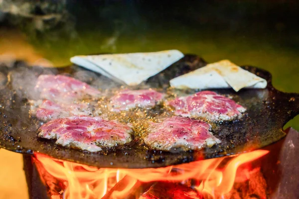 火のそばで夕食 肉の薄い部分は ピタパンと火にフライパンで揚げられています — ストック写真