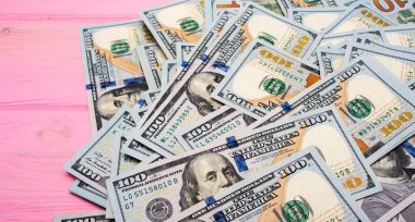 Para geçmişi. Pembe ahşap arka planda dolar. İş ve mali konsept.