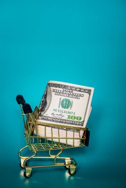 Mavi arka planda Amerikan doları. Finans, iş ve bankacılık. El arabasında Amerikan doları.