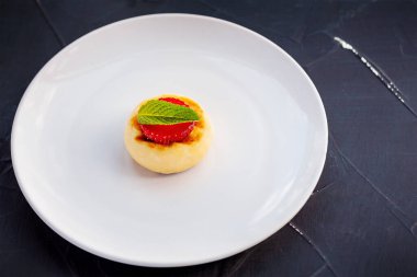 Çilekli peynirli kek ve naneli beyaz tabak. Tatlı nefis..