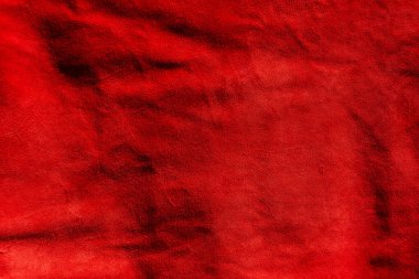Kırmızı süet kumaş. Süetin kırmızı mat arka planı. Pürüzsüz derinin kadife dokusu.