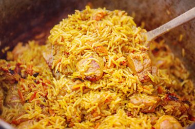 Pilaf cooked on a fire. Preparation of pilaf dish close-up.
