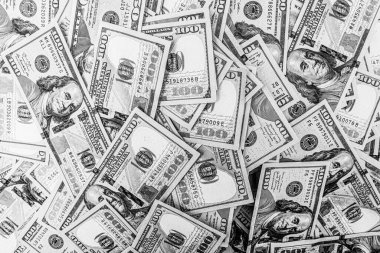 Arka planda Amerikan parası var. 100 dolarlık banknotların siyah beyaz fotoğrafı..