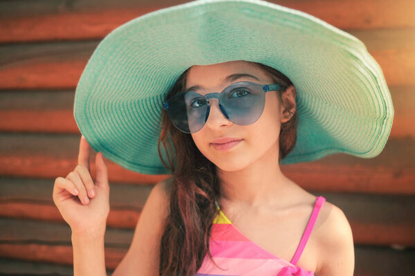 Little girl's summer vacation. A teenage girl in a blue hat and sunglasses.