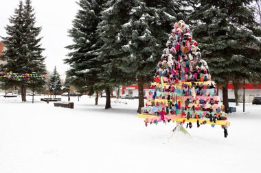 New Year's background with a Christmas wooden tree made of mittens. Place for your text.