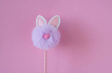 Pembe arka planda sevimli pofuduk leylak tavşancık oyuncağı. Paskalya Konsepti.