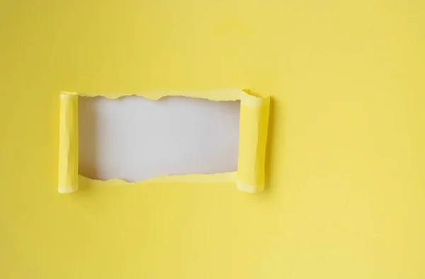 矩形轮廓上的一个洞 白色背景上带有复制空间的扭曲黄色纸 — 图库照片