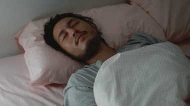 Uyuyan Asyalı kötü rüya görüyor. Evdeki yatak odasında endişeli..