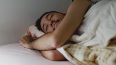 Uyuyan Asyalı tatlı adam evdeki yatak odasında rüya görüyor..