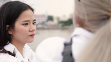 Asyalı lezbiyen çift köprüde dikilirken konuşuyor. Kız arkadaşlarıyla seyahat eden güzel Asyalı kadınlar..