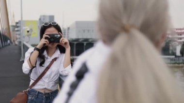 Asyalı lezbiyen çiftler fotoğraf makinesiyle seyahat etmekten zevk alıyorlar. Tatilde eğlenen iki güzel genç kadın..