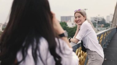 Asyalı lezbiyen çiftler fotoğraf makinesiyle seyahat etmekten zevk alıyorlar. Tatil zamanı eğlenen iki güzel genç kadın. LGBT kavramı.