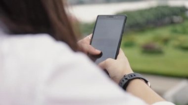 Kapat ellerini güzel Asyalı kadın köprüde dururken internet sitesini karıştırıyor..
