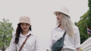 Tayland 'da seyahat ederken el ele tutuşan mutlu Asyalı lezbiyen çiftler. Tatilde eğlenen güzel genç kadınlar. LGBT kavramı.