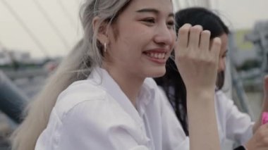 Asyalı lezbiyen çiftler köprüde dururken sabun köpüğü oynuyorlar..